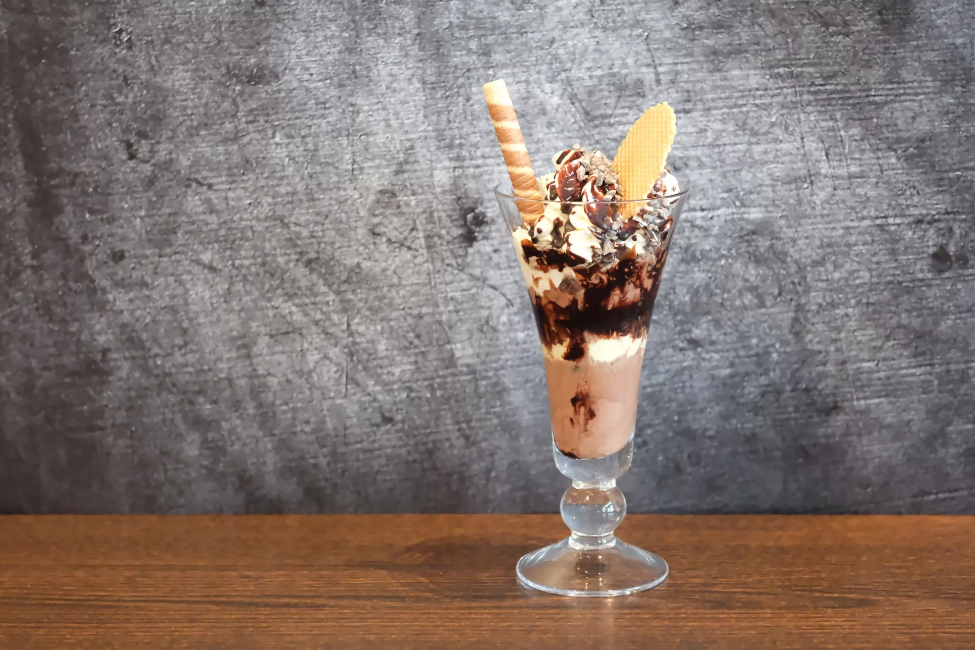 Schokoeisbecher mit Waffeln verziert. Sahne und Schokosirup