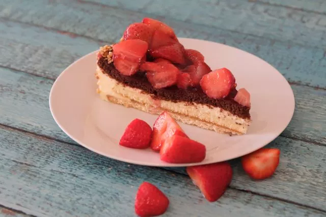 Erdbeerkuchen mit Erdbeeren garniert auf einem Teller