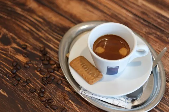 Espresso mit einem Keks auf einem Silbertablett