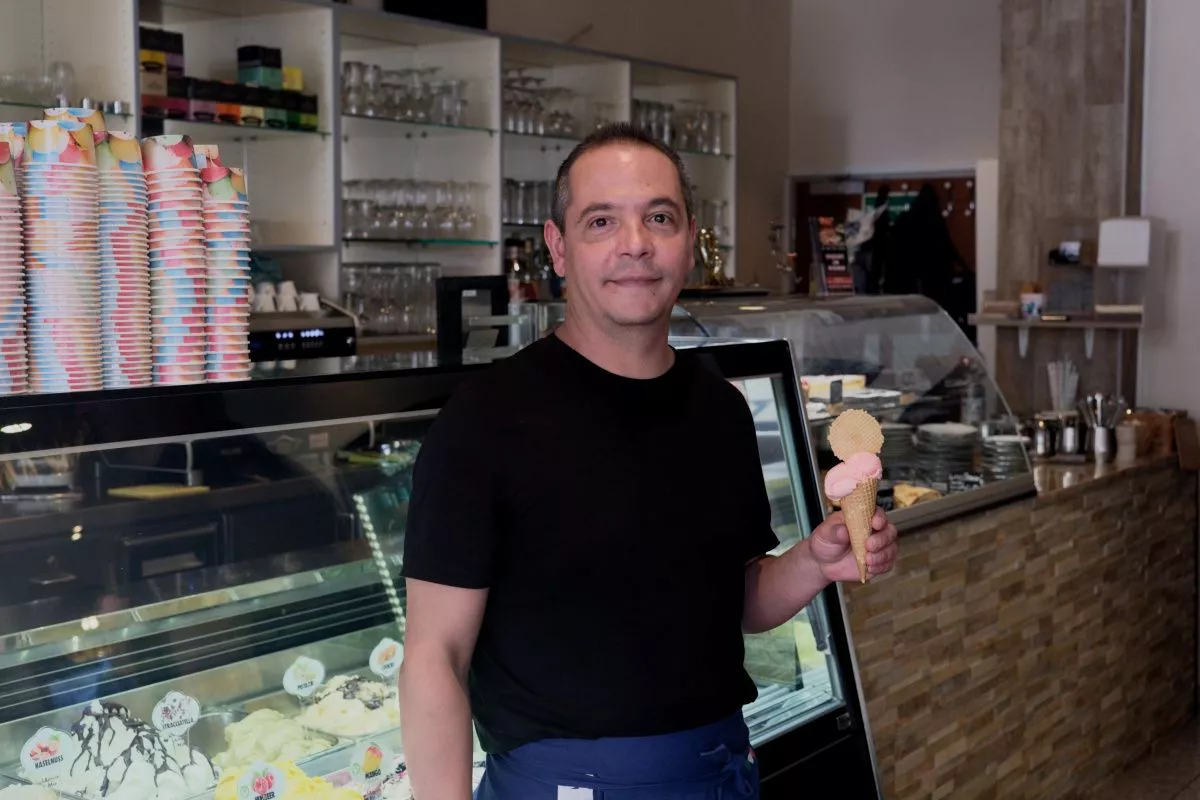 Simone, der Betreiber mit einer Kugel Eis in der Waffel in der linken Hand